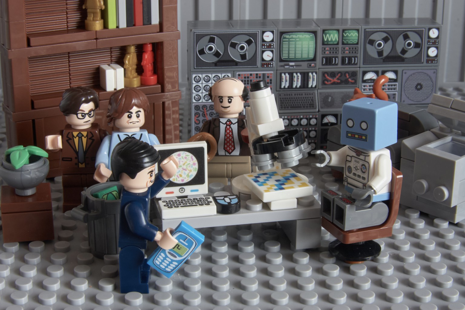LEGO office characters gathered around a microscope and computer to inspect their experiment